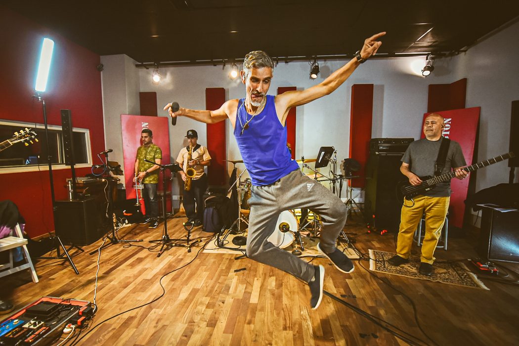 band vocalist jumping, at a band rehearsal, Courtesy of the production company Transistor on a press set for releases.